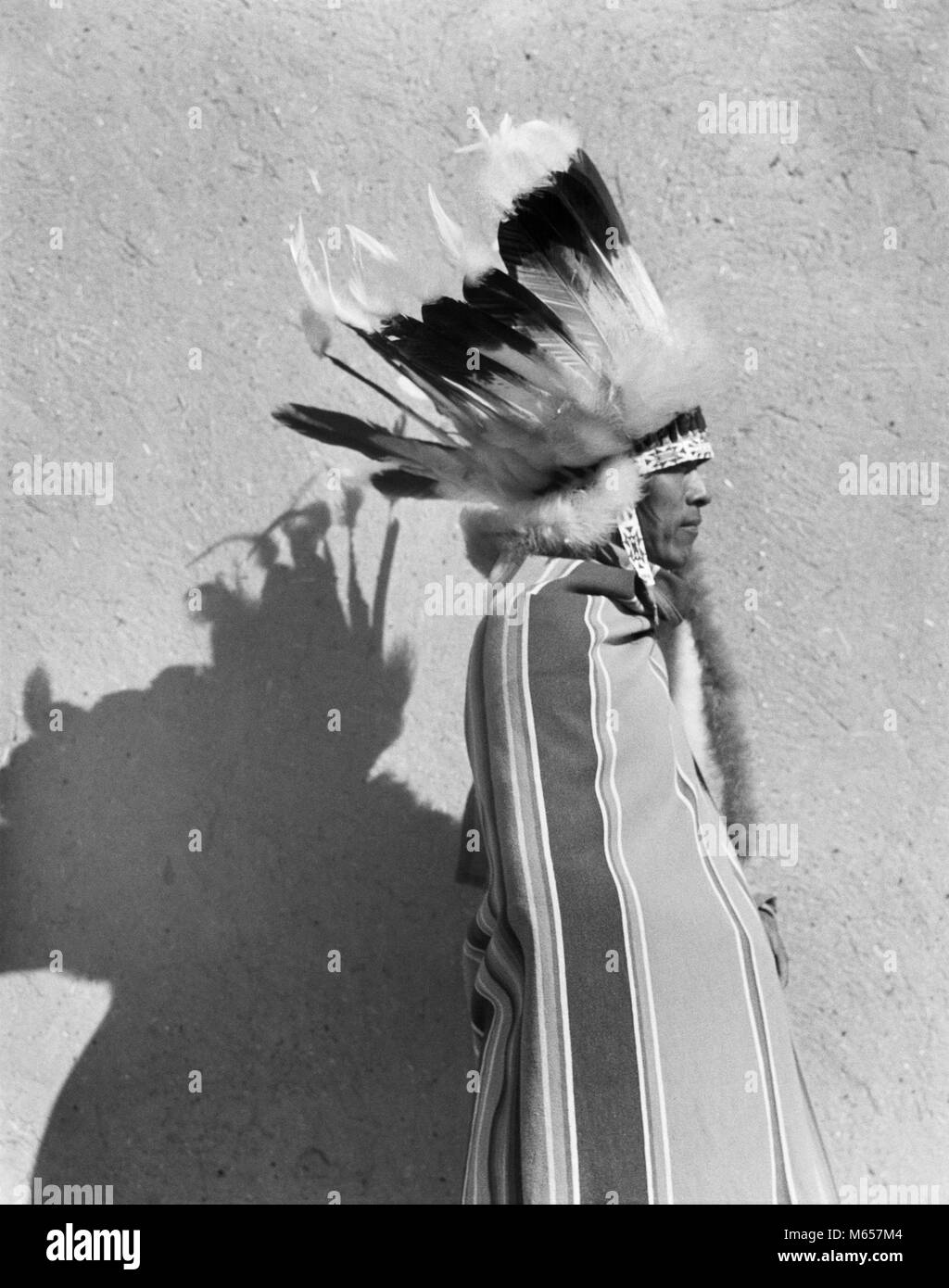 1930s ritratto Native American Indian uomo che indossa la piena di piuma piuma di acconciatura di cofano SAN ILDEFONSO PUEBLO NEL NUOVO MESSICO USA - MI1578 HAR001 HARS PIUME CHIEF LEADERSHIP autorità di orgoglio di acconciatura di cultura dei nativi americani solitaria PUEBLO SAN ILDEFONSO FEATHERED HERITAGE MASCHI MID-adulto MID-Adulto Uomo Nuovo Messico B&W IN BIANCO E NERO IN PIUMA INDIGENI DEL COFANO NM occupazioni in vecchio stile persone Foto Stock