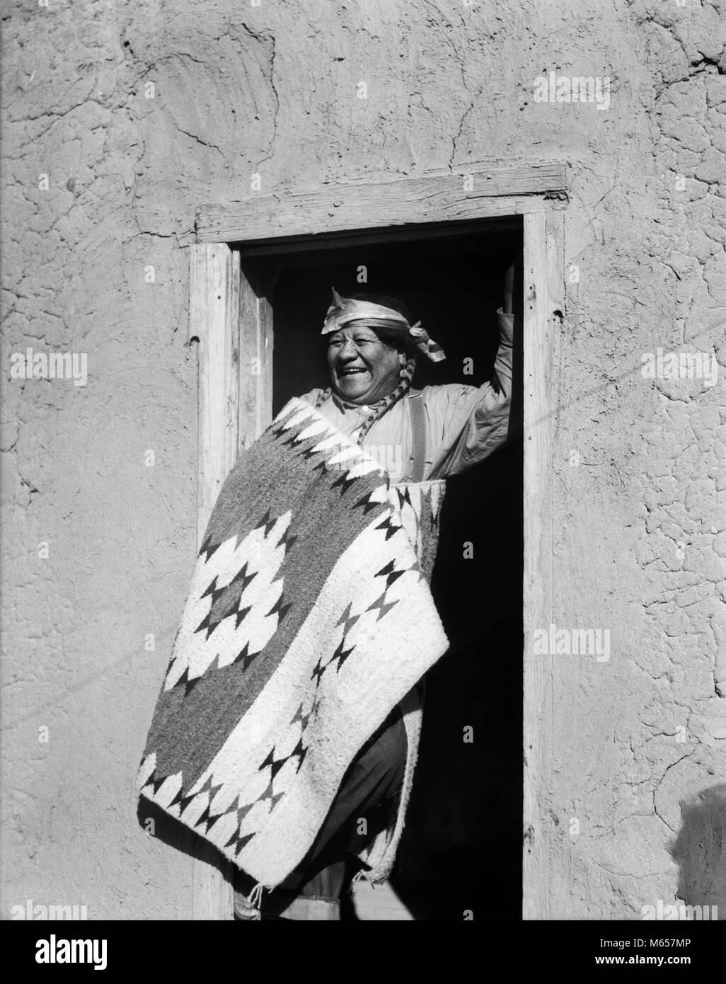 1930s sorridente Native American Indian Man Standing in porta indossando il costume tipico di San Ildefonso PUEBLO NEL NUOVO MESSICO USA - MI1651 HAR001 HARS indiani nostalgia di mezza età uomo di mezza età 50-55 anni 55-60 anni felicità allegro sorriso gioioso NATIVE AMERICAN PUEBLO maschi americani nativi NUOVO MESSICO TIPICO B&W IN BIANCO E NERO ILDEFONSO in vecchio stile persone Foto Stock