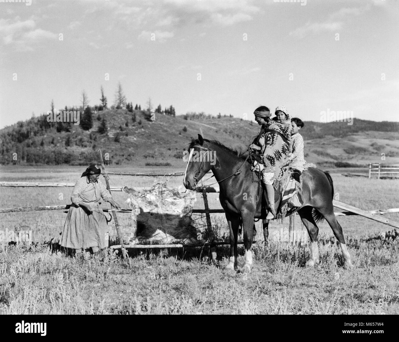 1920s tre Native American bambini a cavallo di parlare alla donna la concia nascondi STONEY SIOUX ALBERTA CANADA - ho921 HAR001 HARS 1 capretti comunicazione stile CANADA CAVALLI FIGLI LIFESTYLE STORIA FEMMINE FRATELLI HOME VITA spazio copia a tutta lunghezza LADIES FIGLIE INDIANI CARING WESTERN animali ruvida fratelli sorelle NOSTALGIA NORD AMERICA STARE INSIEME STORICO NORTH AMERICAN CAVALLO MAMMIFERI Nascondi mamme gemelli visitando Native American piccolo gruppo di persone Canadian Rockies STONEY SIOUX ALBERTA novellame maschi mammifero concia B&W IN BIANCO E NERO indigeni in vecchio stile persone Foto Stock