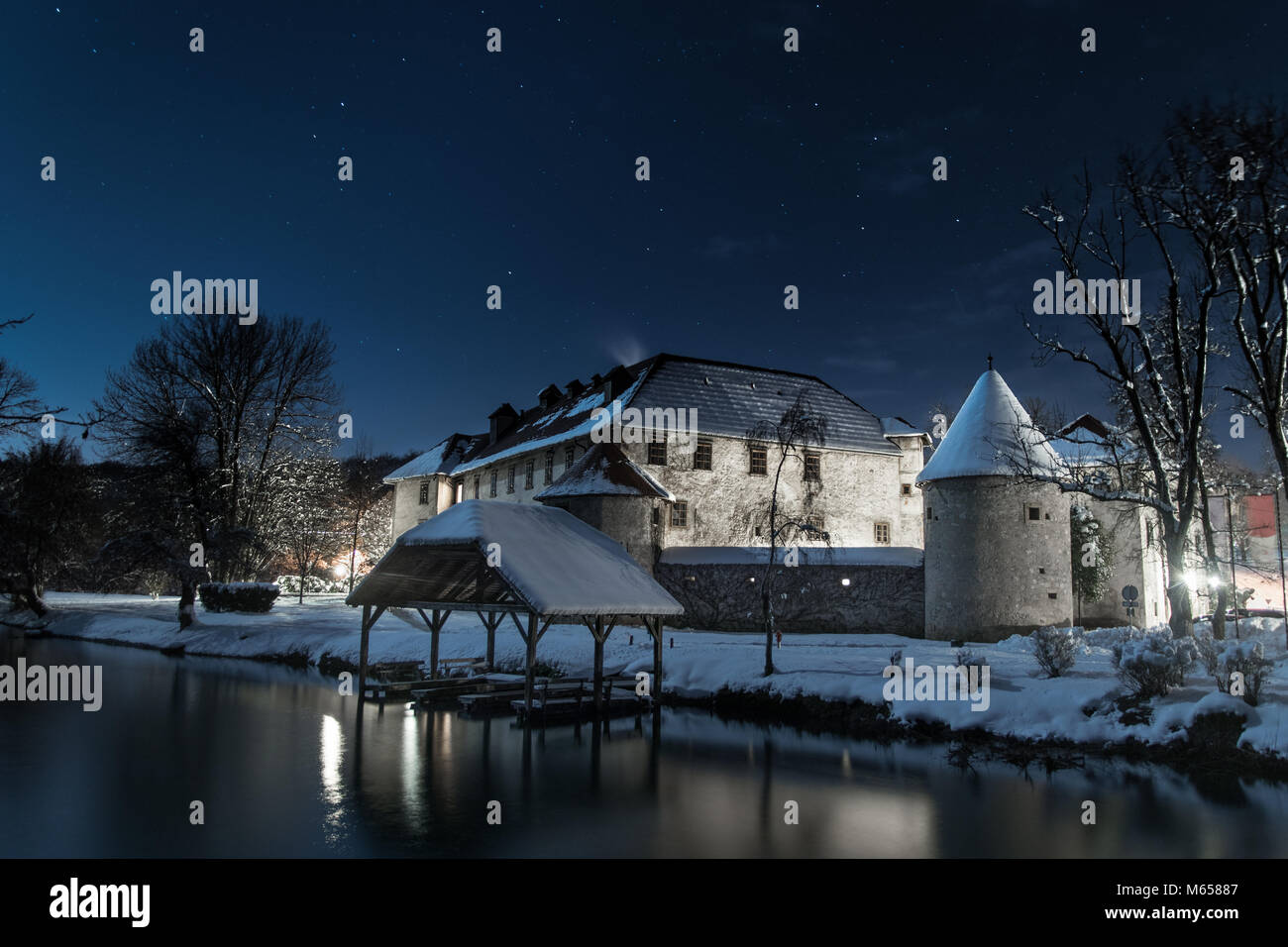Antico castello su un isola del fiume di notte durante l'inverno. Le stelle sono visibili su una chiara notte. Foto Stock