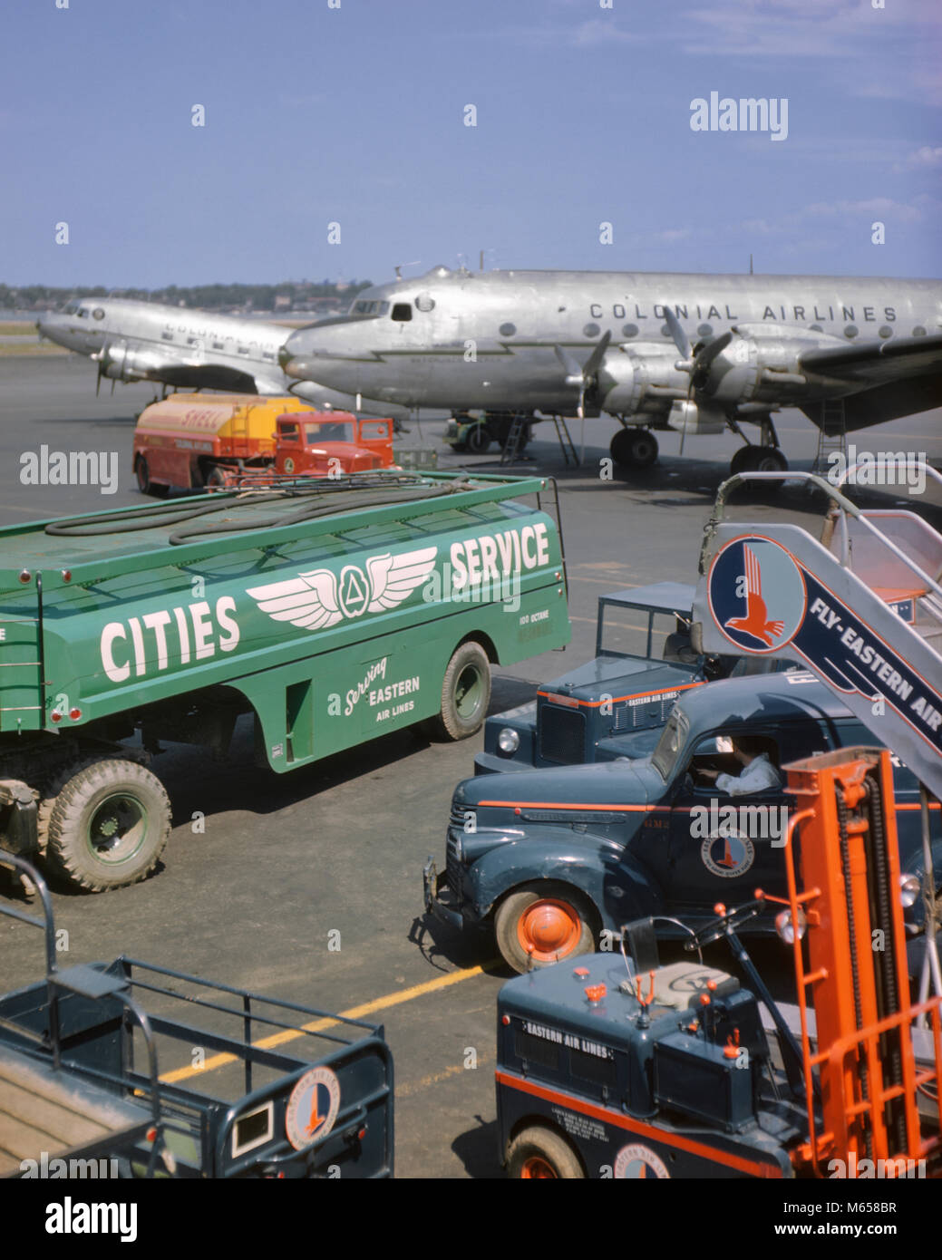 Anni Cinquanta compagnie coloniale aereo su asfalto CON CARRELLI ELEVATORI A BENZINA IN PRIMO PIANO L'aeroporto La Guardia di New York STATI UNITI D'AMERICA - ka9171 CPC001 HARS PASQUA IN PRIMO PIANO LE COMPAGNIE AEREE AUTOSCALE LAGUARDIA BAGAGLI comunale del veicolo in vecchio stile di veicoli di servizio Foto Stock
