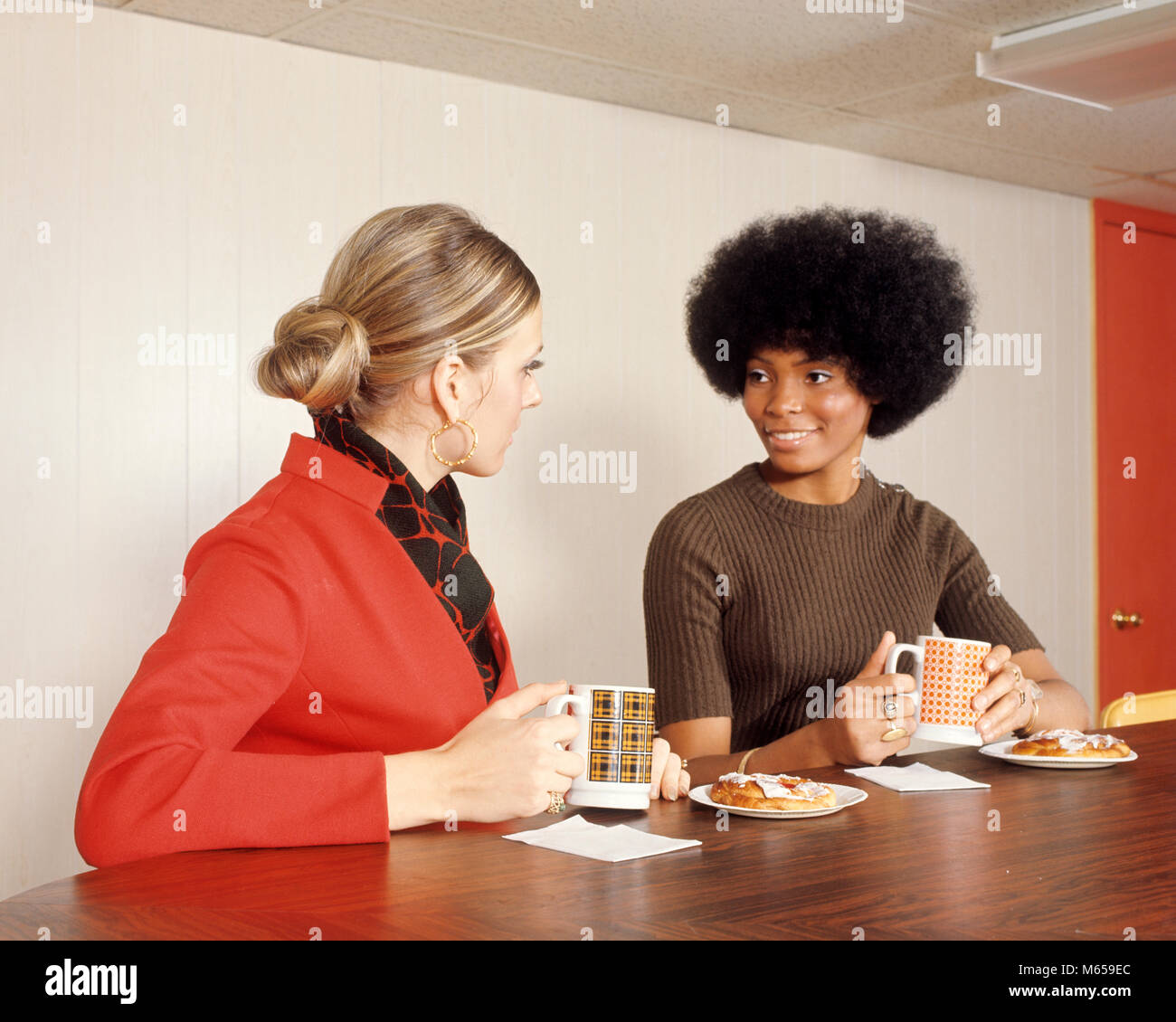 Anni Settanta americano africano e Caucasico DONNA CON Caffè Caffè danese SHOP COUNTER - kd2646 HAR001 HARS TAZZE IN INTERNI NOSTALGIA convivere 20-25 anni 25-30 anni ragazza felicità stili afro-americani afro-americani e afro-americani African American Connection Mode giovane donna adulta danese in vecchio stile persone Foto Stock