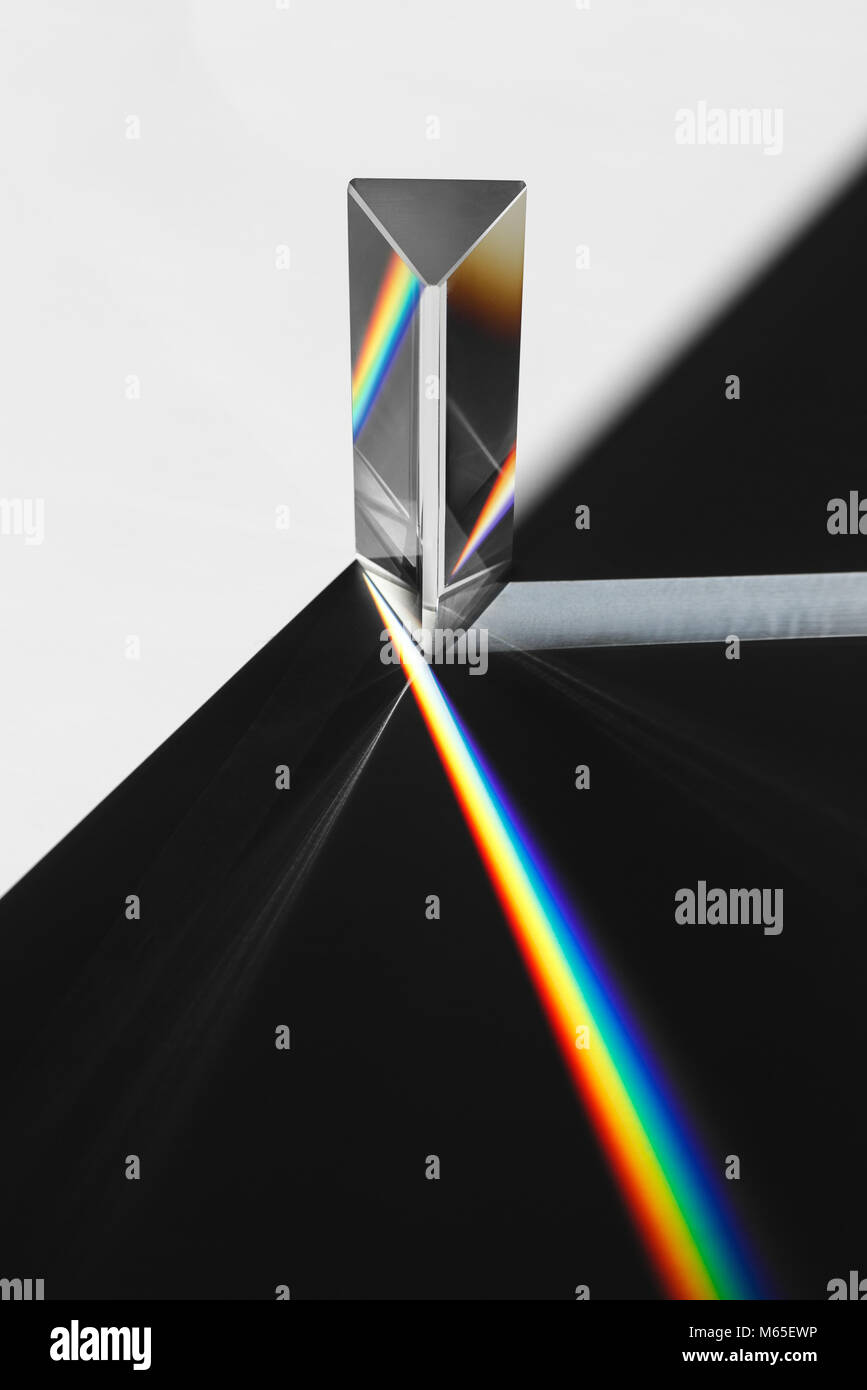 Un prisma disperde la luce del sole si divide in un spettro su uno sfondo bianco. Foto Stock