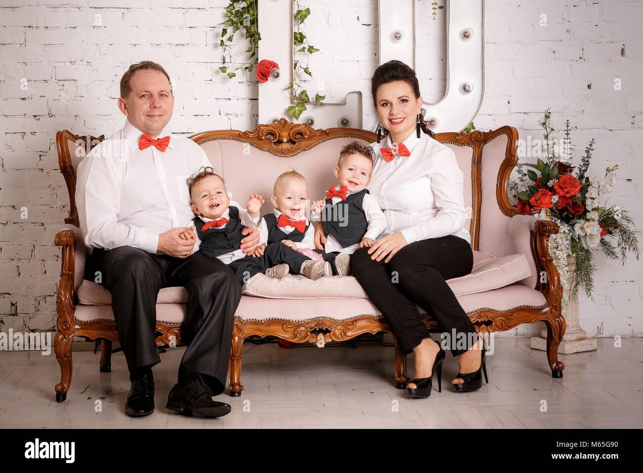 Grande famiglia felice: madre, padre, triplette figli Foto Stock