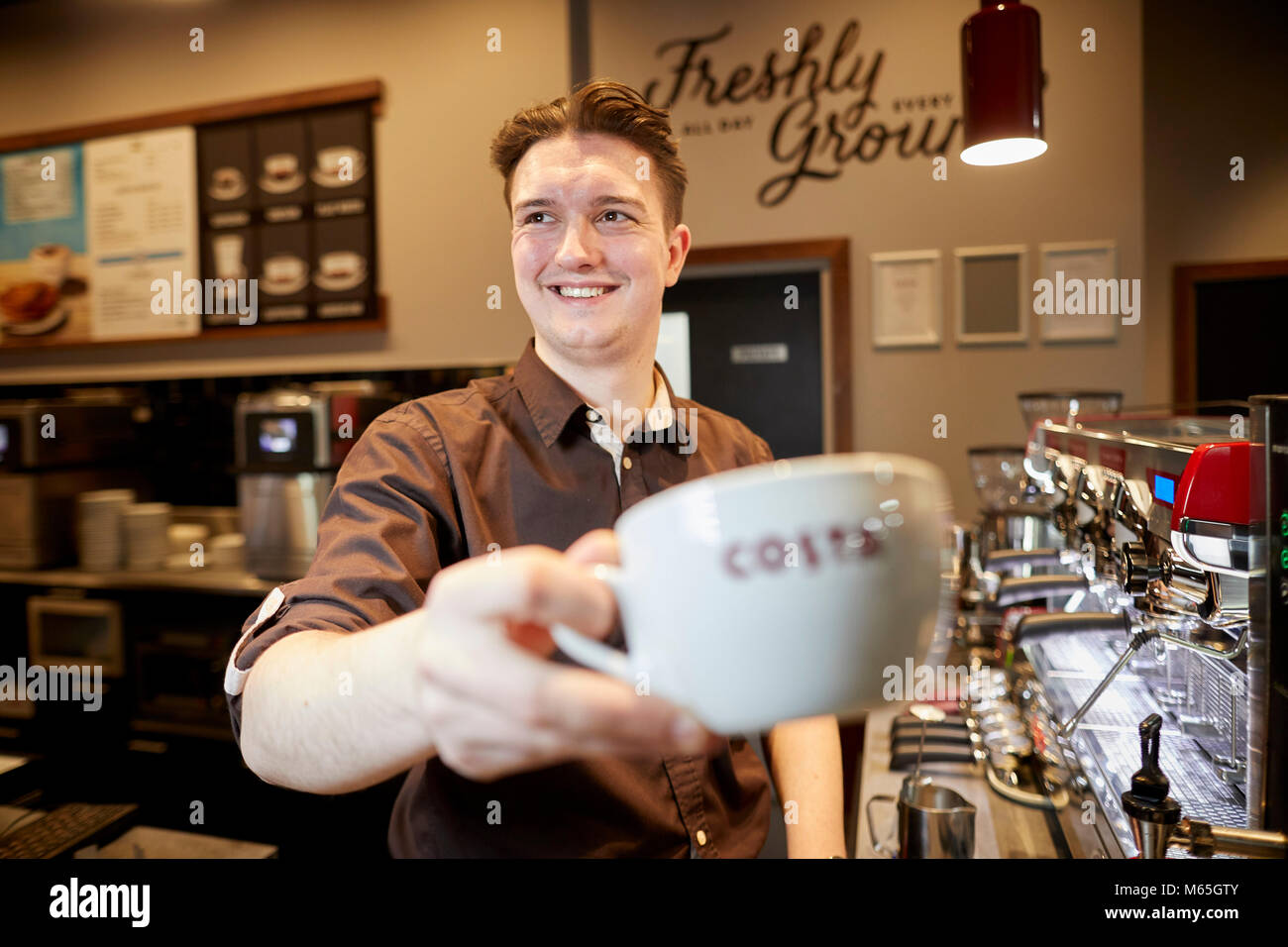Costa Coffee shop lavoratore in negozio Foto Stock
