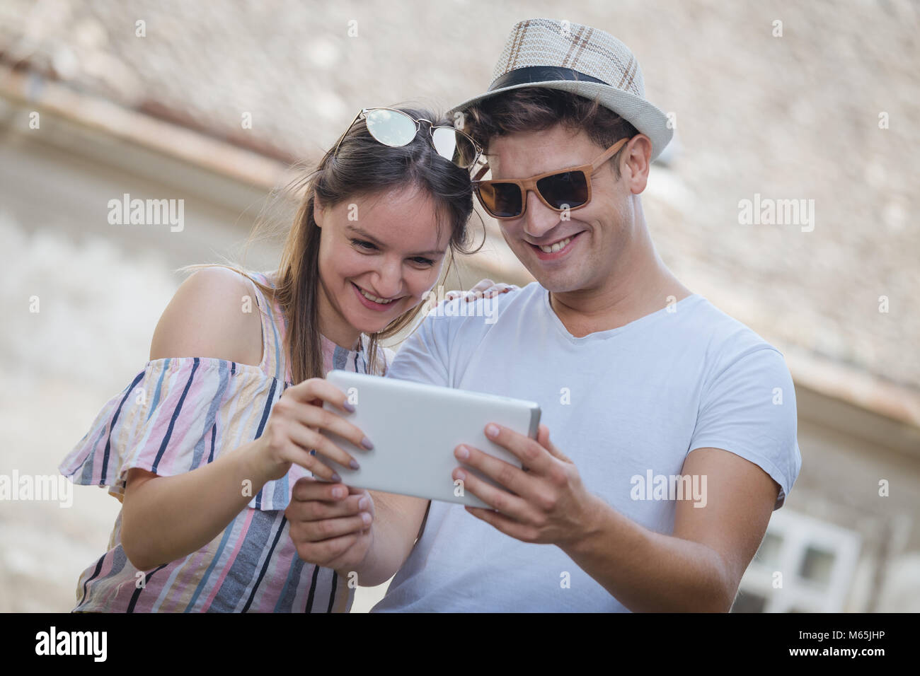 Giovane turista l uomo e la donna guardando insieme a tavoletta digitale del dispositivo e alla ricerca per la prossima meta da visitare Foto Stock