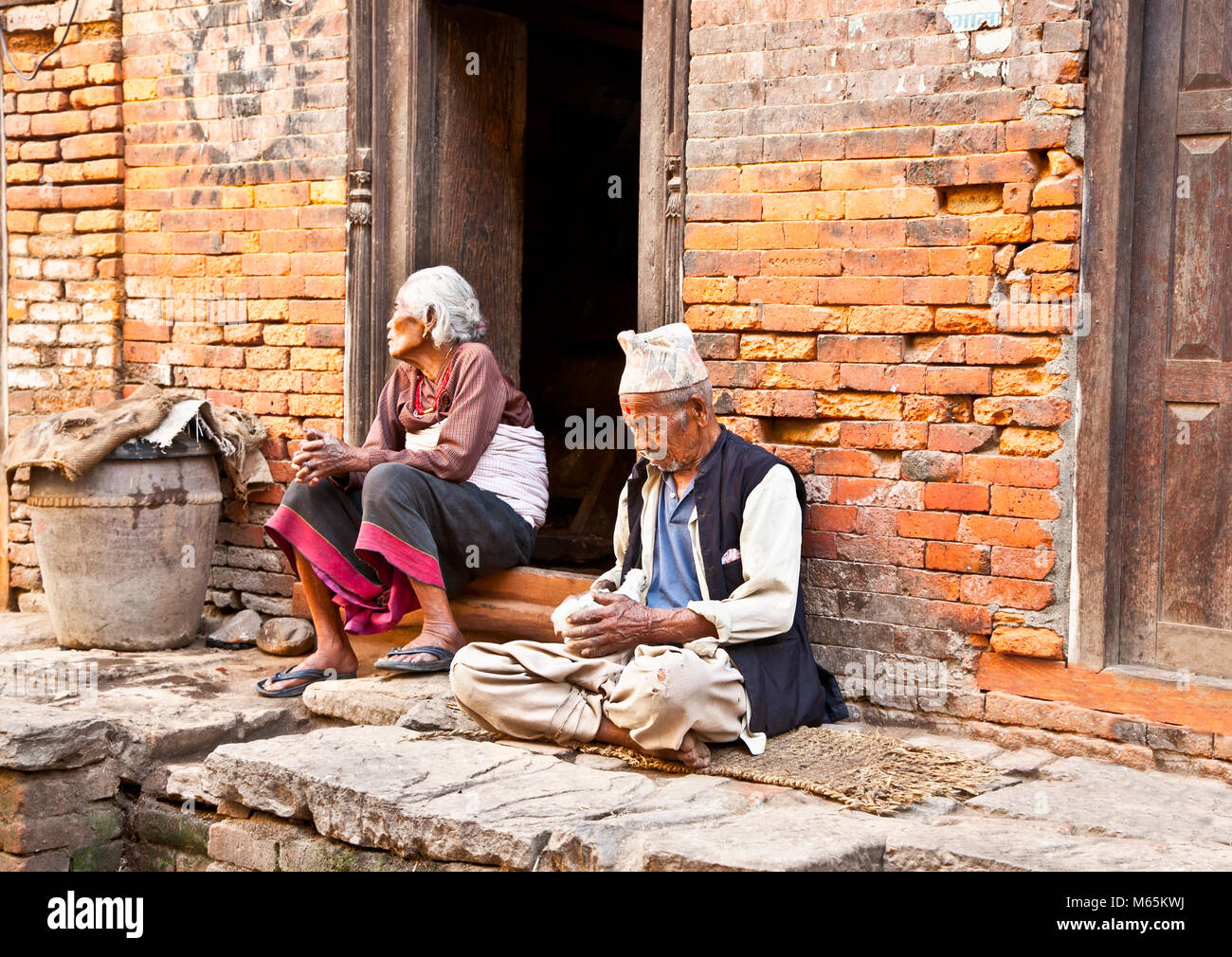 BHAKTAPUR,NEPAL-maggio 20:vecchia donna e uomo seduto intrecciate le loro case nel Maggio 20, 2013, Bhaktapur,Nepal.Bhaktapur è una delle 3 città regie nel Ka Foto Stock