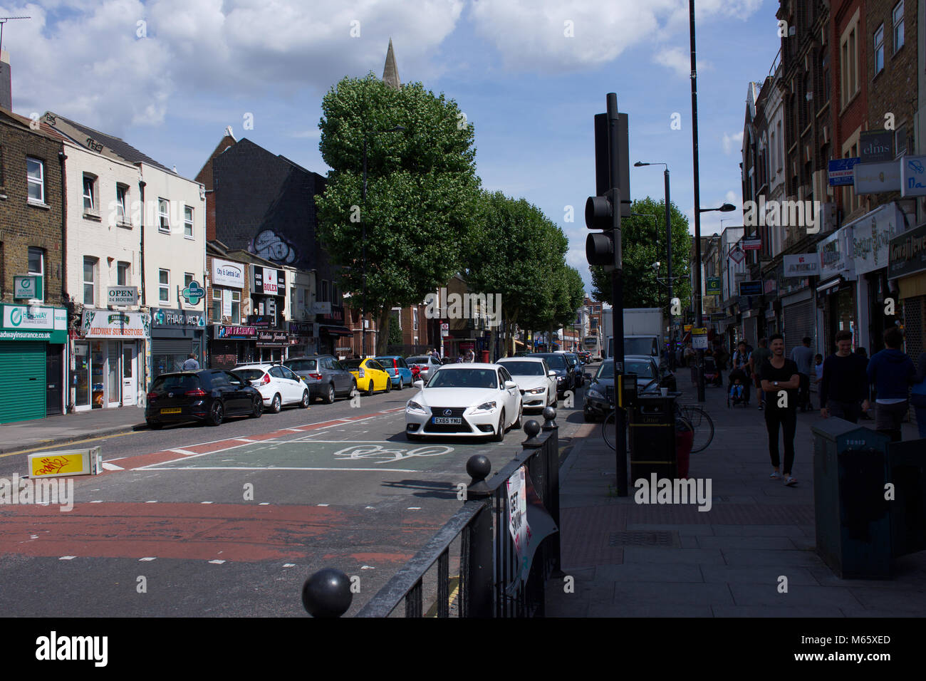 Bethnal Green,High Street,sul giorno di estate.Street,edifici,auto persone casualmente a piedi.London,Oriente,Regno Unito.Un lato della strada in ombra.6.08.2017. Foto Stock