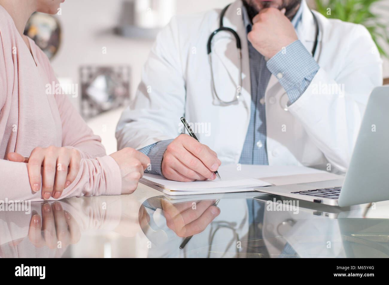 Medico è iscritto la prescrizione per il paziente Foto Stock