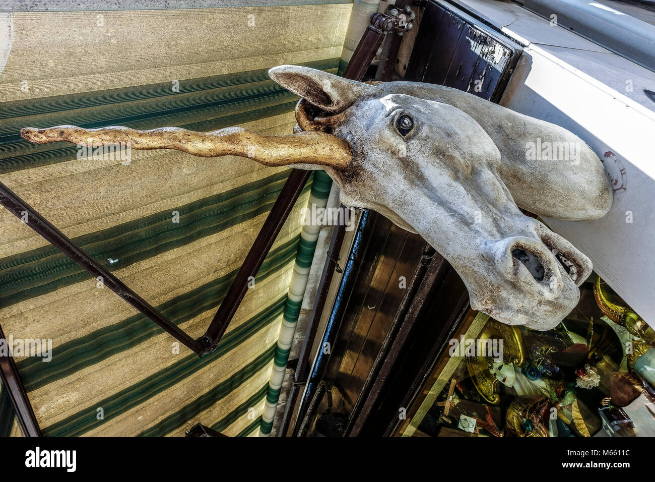 Maschera bianca grande unicorno, come segno, all'esterno di un tipico negozio di maschere di carnevale veneziane. Venezia magica, Italia, Europa, Unione europea, UE. Foto Stock