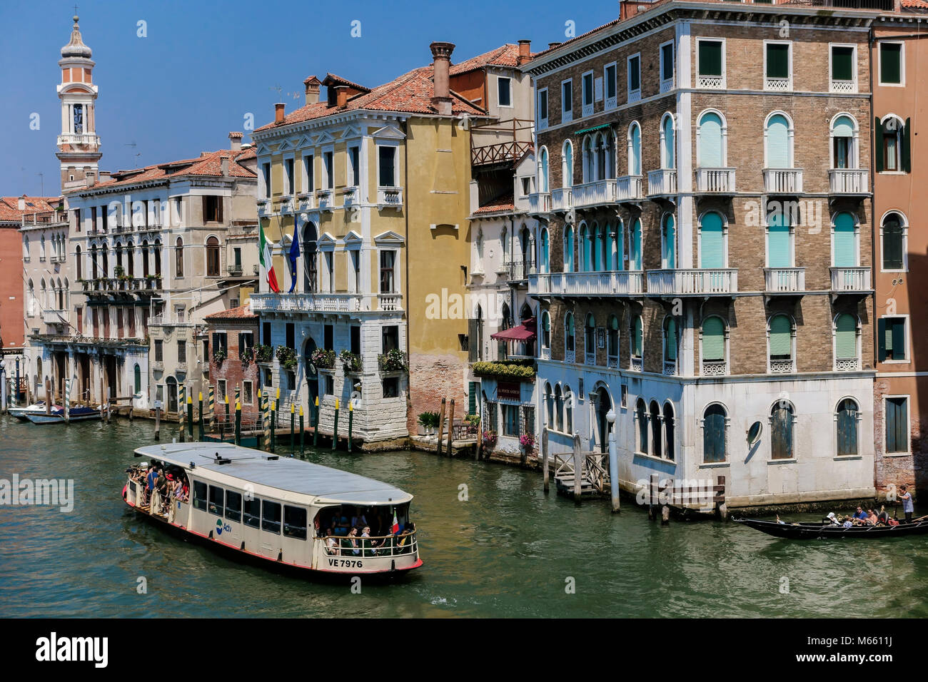 Vaporetto, vaporetto, traghetto. Tipiche facciate dell'edificio sul Canal Grande. Venezia magica, Italia, Europa, UE. Cielo blu chiaro. Foto Stock