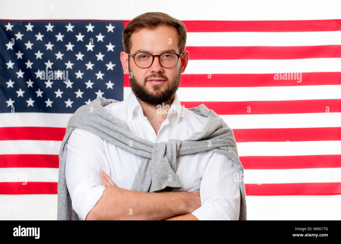 Bandiera americana. Sorridente giovane uomo su Stati Uniti bandiera dello sfondo. USA celebrare il 4 di luglio. Foto Stock