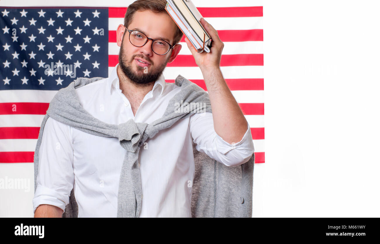Sorridente giovane uomo su Stati Uniti bandiera dello sfondo. Studente è di apprendimento della lingua inglese come lingua straniera. Bandiera americana. Foto Stock
