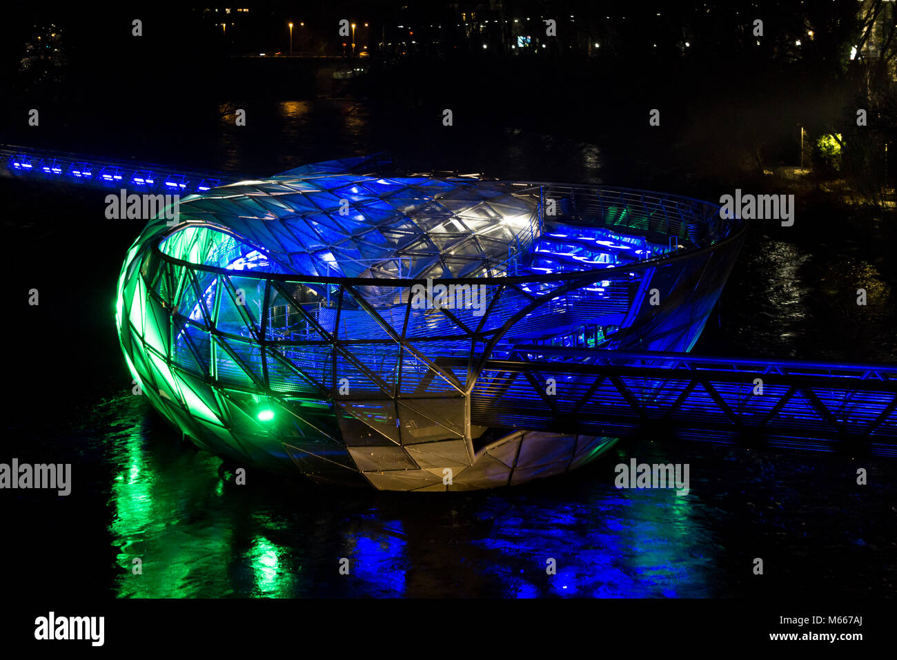 Graz, Austria - 08.02.2018: luce blu e verde sul Murinsel sul fiume Mur Foto Stock