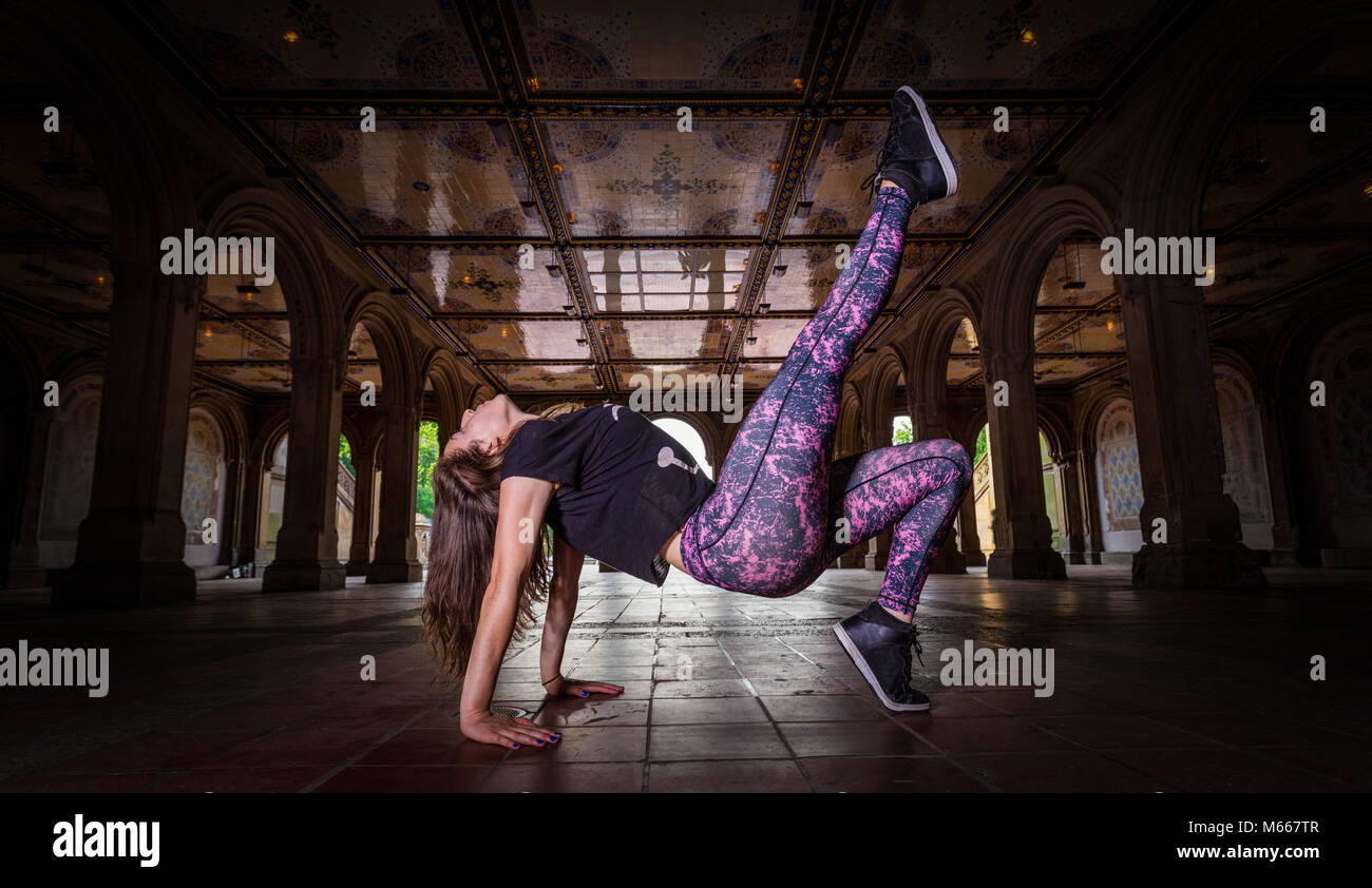 Giovani Caucasian Brunette donna esegue la danza hip hop di indossare abbigliamento sportivo sotto il Minton piastrelle a Bethesda Arcade Foto Stock