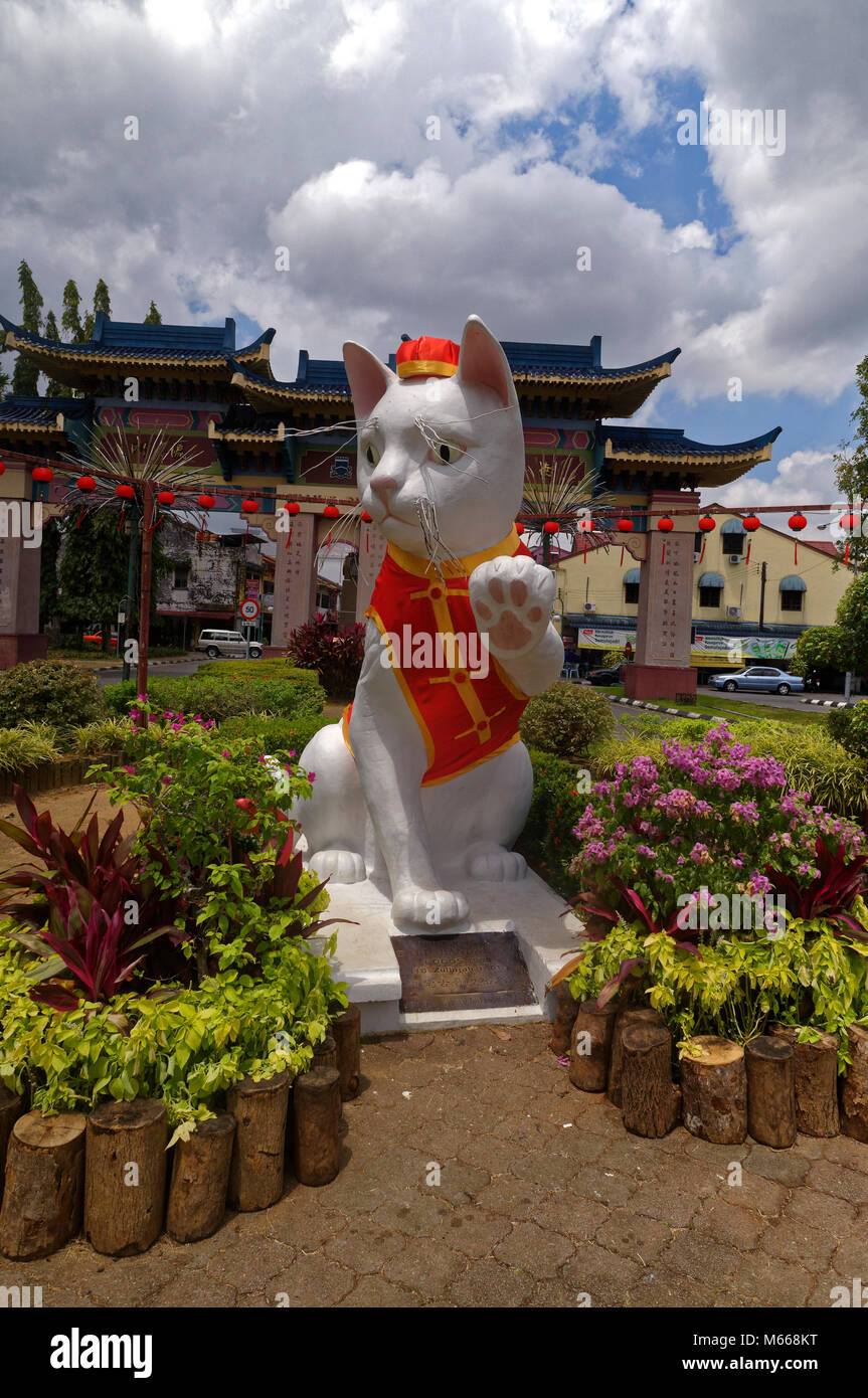 Il Landmark gatto bianco statua sulla Jalan Pdungan, Kuching, Sarawak, Malaysia, vestito di rosso per il Capodanno cinese Foto Stock