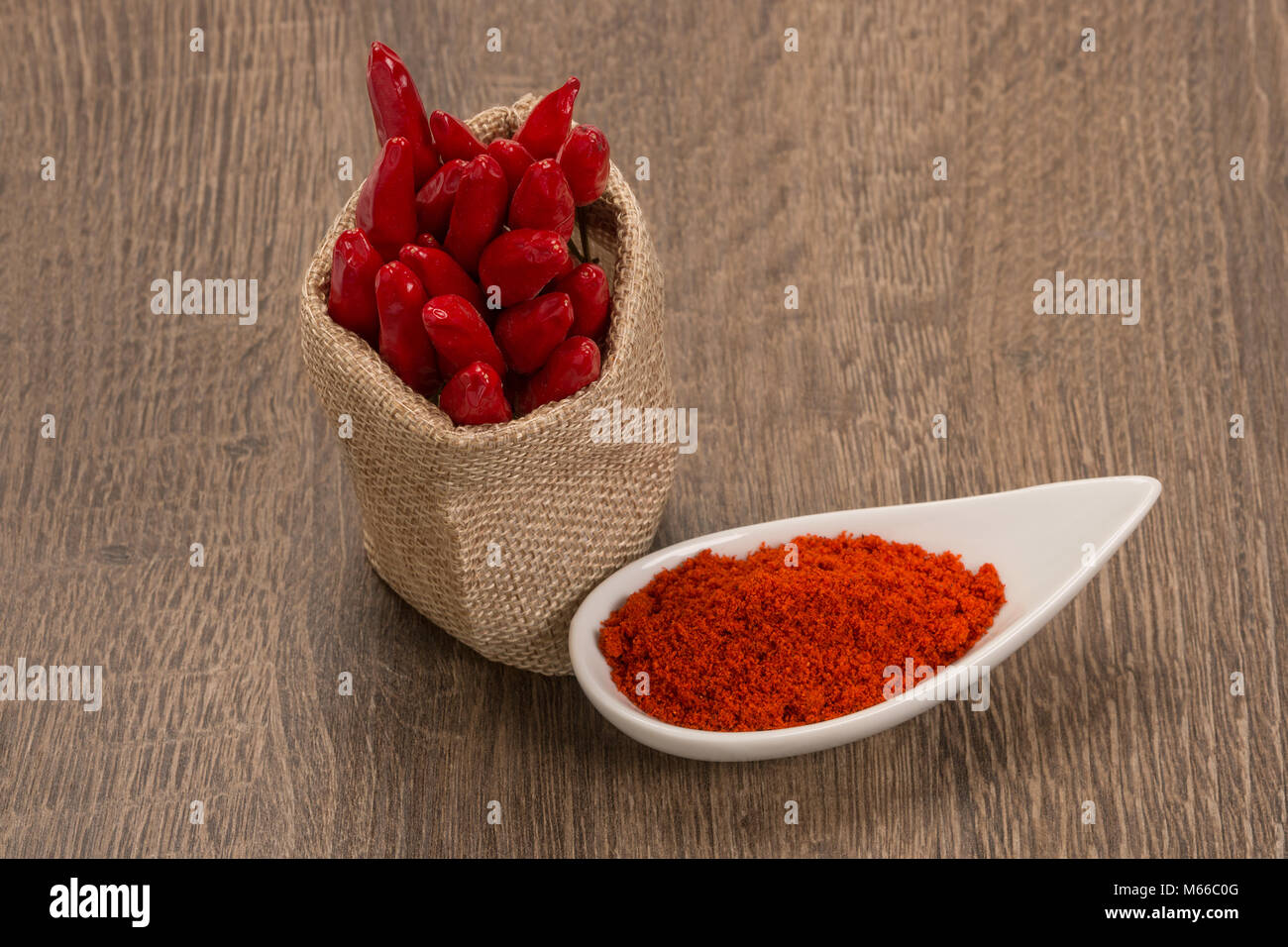 Polvere di peperoncino rosso su uno sfondo di legno Foto Stock