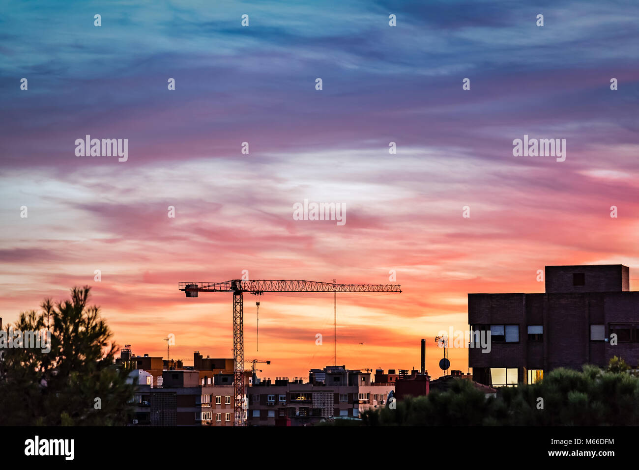 Gru da cantiere sulla skyline di Madrid al bellissimo tramonto. Foto Stock