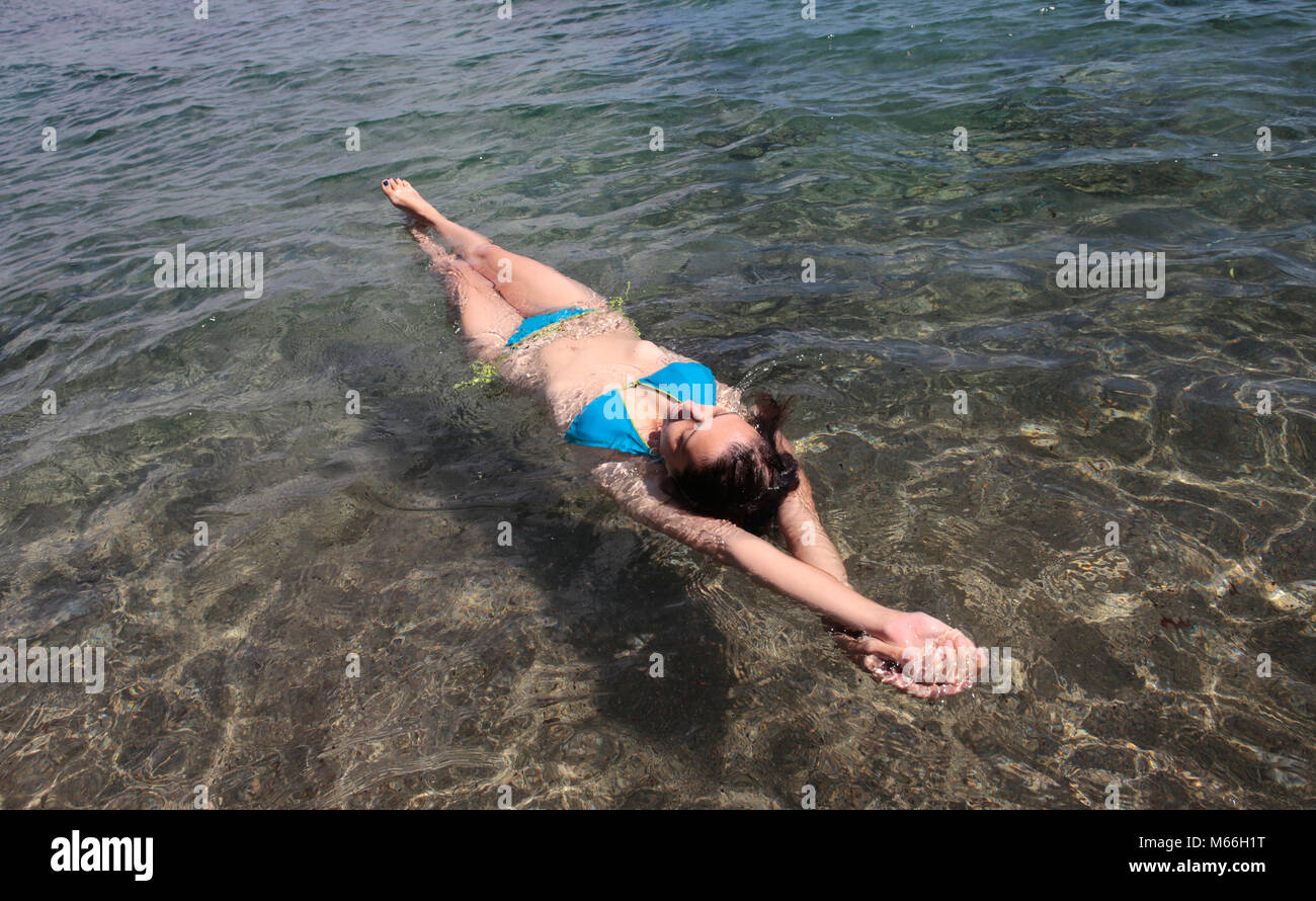 Donna che galleggia in mare, Punta Negra, Maiorca, Spagna Foto Stock