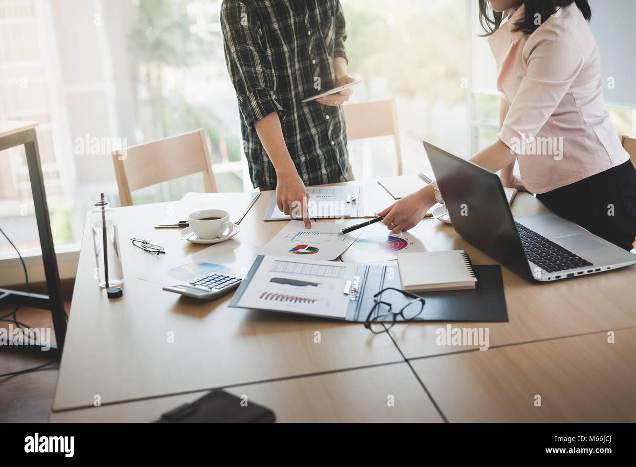 Asian imprenditrice discussione e scambio di idee con il giovane uomo freelance in sala riunioni. Business la società co-operare con esternalizzare il concetto di lavoratore. Foto Stock