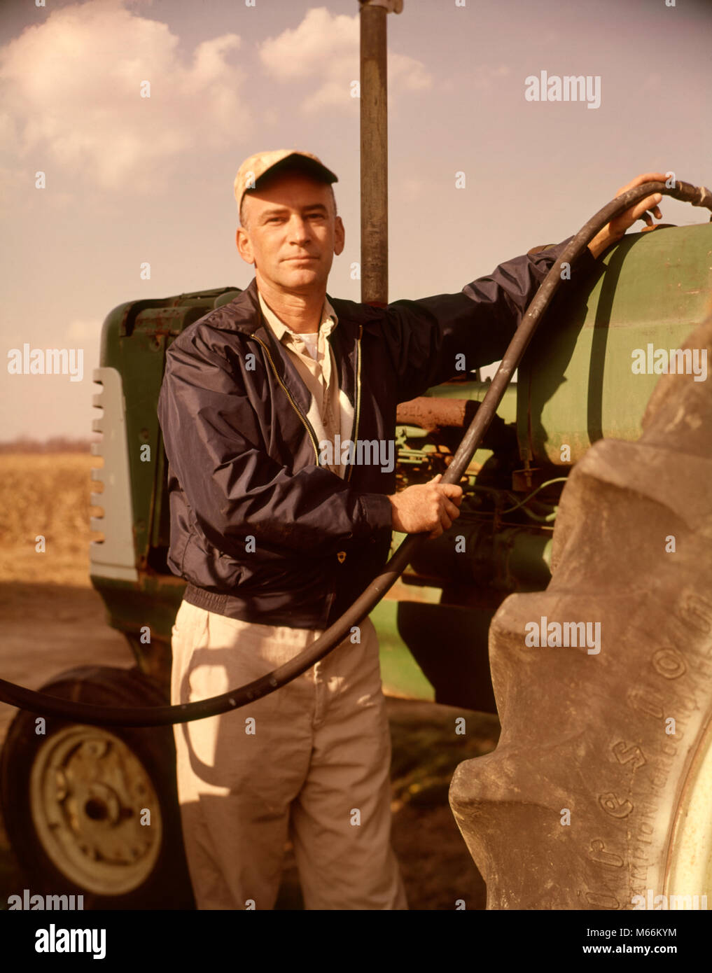 Anni sessanta RITRATTO DI GRAVE uomo agricoltore guardando la telecamera in  carburante del trattore - kf3944 HAR001 HARS spazio copia di metà lunghezza  CRESCIUTI AGRICOLTURA LA FIDUCIA DEL CARBURANTE nostalgia di mezza