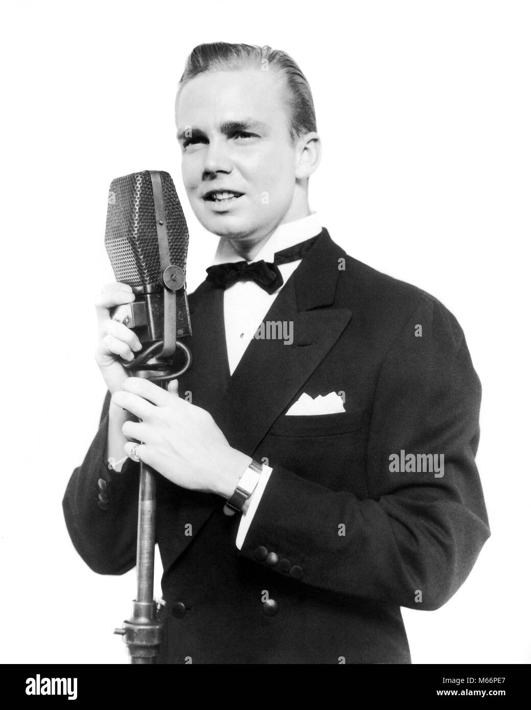 1920s 1930 uomo sorridente cantante RADIO INTRATTENITORE CROONER in smoking cantare nel microfono - r10906 HAR001 HARS professione di fiducia di intrattenimento NOSTALGIA 20-25 anni 25-30 anni performing arts abilità Competenze occupazione BROADCASTING JAZZ STILI PERFORMER ANNUNCIATORE CARRIERE CANZONE VOCAL INTRATTENITORE CRESCITA MODE HOST attori sentimentale interpreti canzoni popolari intrattenitori bow tie CROONER maschi giovani adulti annunciando MAN B&W BIG BAND in bianco e nero di etnia caucasica accompagnerà EMCEE Maestro delle Cerimonie di MC occupazioni in vecchio stile persone STYLIST Foto Stock