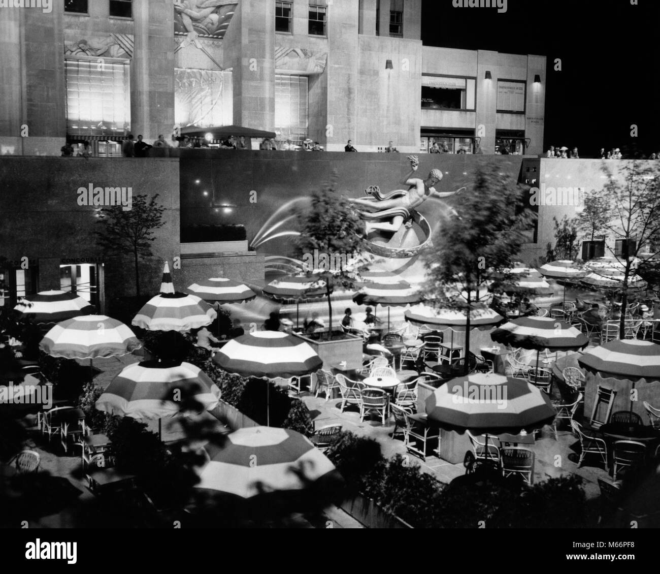 1930s CAFE OMBRELLONI TAVOLI SERATA AL PROMETEO FONTANA ROCKEFELLER CENTER MANHATTAN NEW YORK CITY NY USA - r1622 HAR001 HARS notturno di roccia 30 B&W BIG APPLE IN BIANCO E NERO Caffè vecchio stile Prometeo Foto Stock