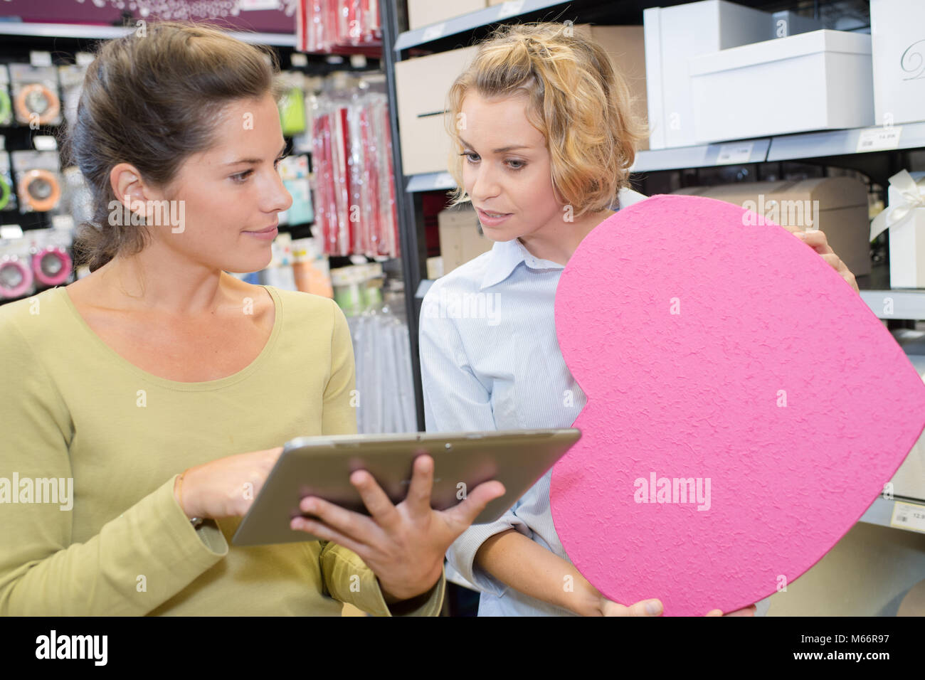 Happy shop assistant con tablet pc aiutando donna Foto Stock