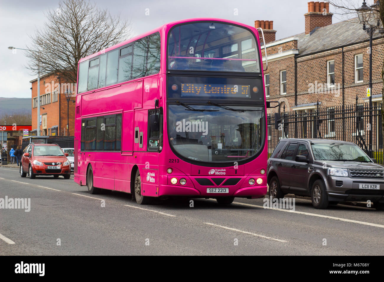 Un rosa luminoso double deck di trasporto pubblico bus sulla Crumlin Road a Belfast Irlanda del Nord Foto Stock