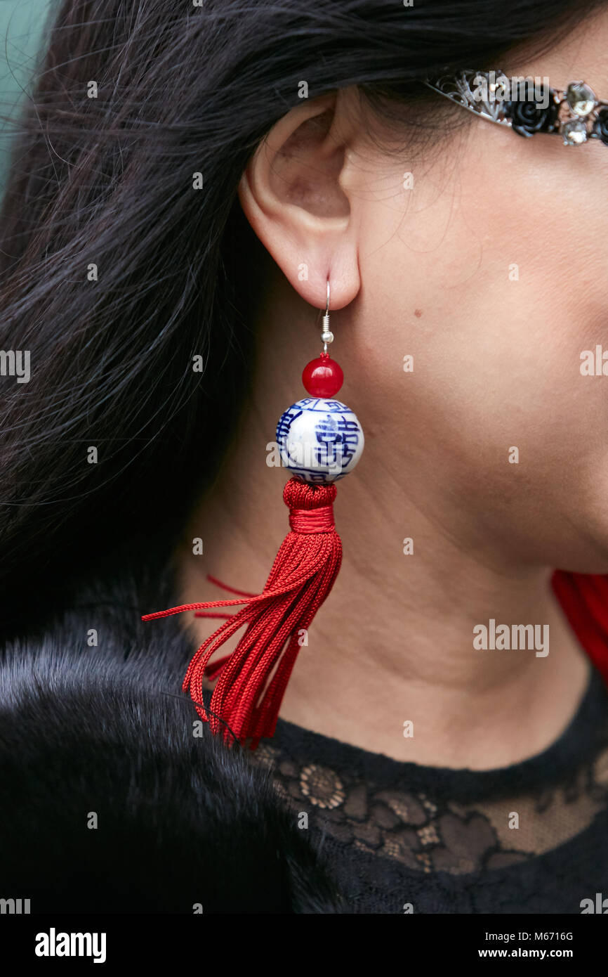 Milano - 25 febbraio: Donna con orecchini con sfera bianco con decorazioni blu e rosso prima di frange Emporio Armani fashion show, la Fashion Week di Milano Foto Stock