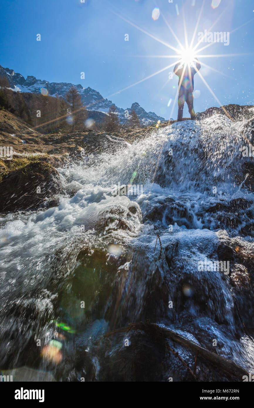 Sunburst sul torrente alpino, Entova Alp, Malenco Valley, provincia di Sondrio e della Valtellina, Lombardia, Italia Foto Stock