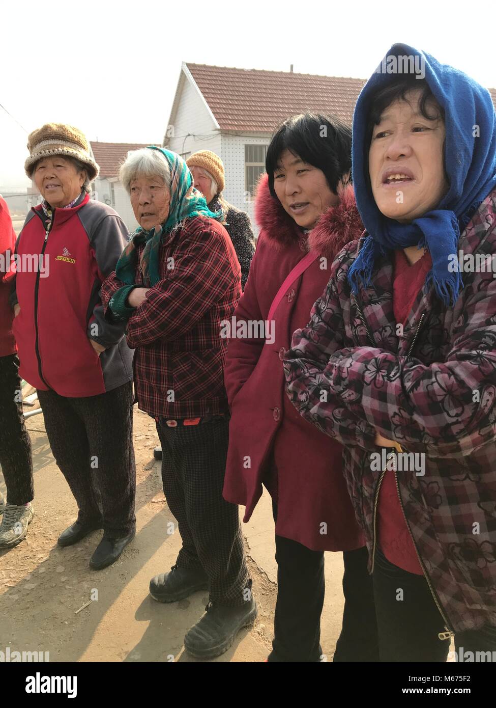 Dispensa - 17 gennaio 2018, Cina, Rongcheng, Nanqiaotoucun: gli abitanti di un villaggio di stand per la strada. Essi ancora non si sa nulla circa il nuovo credito sociale sistema. Il est costa cinese la città del Mar Giallo è un pioniere di alcune decine di progetti pilota in Cina, con la quale un capillare sistema di punto di 'sociale affidabilità' è di essere introdotto nel 2020. Il numero di punti ottenuti si differenzia il bene dal male i cittadini e serve come un certificato personale di buona condotta.· Nessun filo servizio · Foto: Andreas Landwehr/dpa Foto Stock