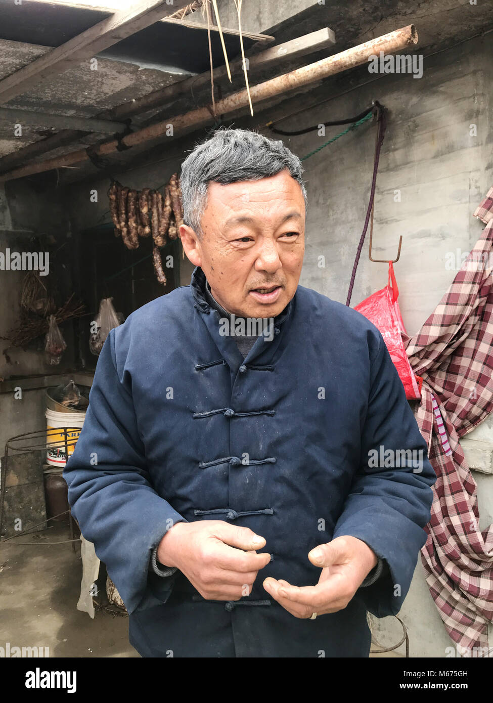 Dispensa - 17 gennaio 2018, Cina, Rongcheng: Mu Linming, un abitante di un villaggio, sorge di fronte a casa sua e parla del nuovo credito sociale sistema. Il est costa cinese la città del Mar Giallo è un pioniere di alcune decine di progetti pilota in Cina, con la quale un capillare sistema di punto di 'sociale affidabilità' è di essere introdotto nel 2020. Il numero di punti ottenuti si differenzia il bene dal male i cittadini e serve come un certificato personale di buona condotta.· Nessun filo servizio · Foto: Andreas Landwehr/dpa Foto Stock