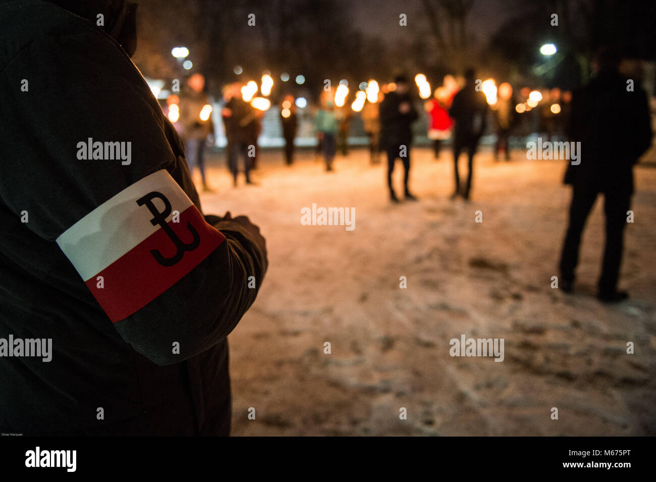 Cracovia in Polonia. 28 Feb, 2018. Un membro del conservatore polacco ala destra movimento visto con il suo partito politico bracciale logo come egli frequentare una marcia silenziosa per la Giornata Nazionale del ricordo dei maledetti i soldati in Cracovia. Credito: Omarques 01032018  19 .jpg/SOPA Immagini/ZUMA filo/Alamy Live News Foto Stock