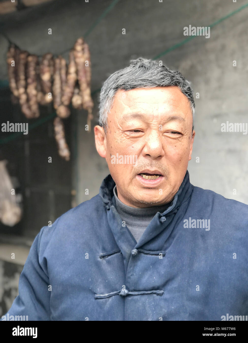 Dispensa - 17 gennaio 2018, Cina, Rongcheng: Mu Linming, un abitante di un villaggio, sorge di fronte a casa sua e parla del nuovo credito sociale sistema. Il est costa cinese la città del Mar Giallo è un pioniere di alcune decine di progetti pilota in Cina, con la quale un capillare sistema di punto di 'sociale affidabilità' è di essere introdotto nel 2020. Il numero di punti ottenuti si differenzia il bene dal male i cittadini e serve come un certificato personale di buona condotta.· Nessun filo servizio · Foto: Andreas Landwehr/dpa Foto Stock