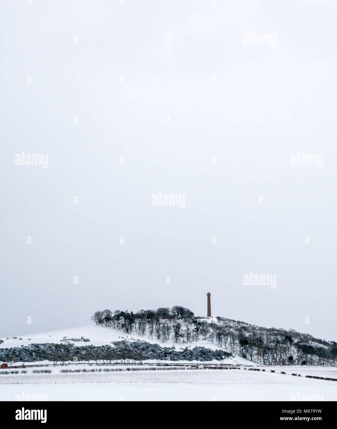 East Lothian, Scozia, Regno Unito, 1 marzo 2018. Regno Unito: Meteo sulla gazzetta primo giorno di primavera, neve portato dal clima artico portato dalla cosiddetta "Bestia da est'. Campi innevati guardando verso Byres collina con torre Hopetoun monumento contro un cielo nevoso Foto Stock