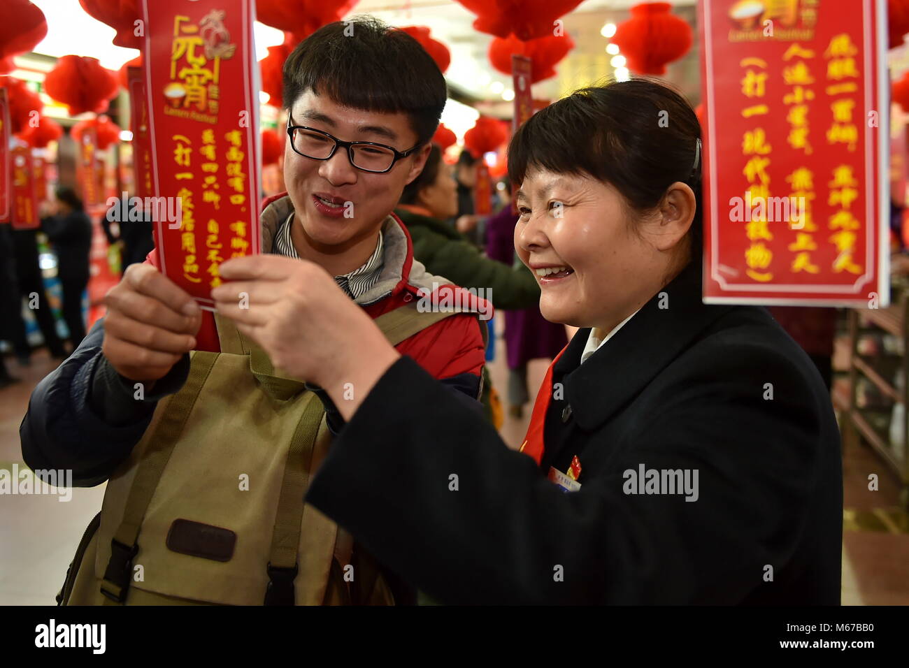 (180301) -- TAIYUAN, 1 marzo 2018 (Xinhua) -- un operaio ferroviario (R) e un passeggero indovinare lanterna enigmi durante un'attività di salutare la festa delle lanterne a Taiyuan stazione ferroviaria nel nord della Cina di nella provincia di Shanxi, 1 marzo 2018. La festa delle lanterne cade il 2 marzo di quest'anno. (Xinhua/Cao Yang)(mcg) Foto Stock