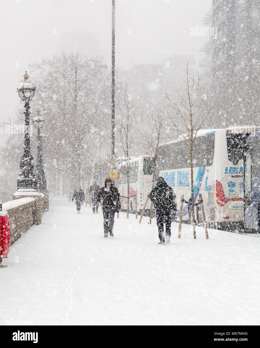 Londra, UK, 28 febbraio 2018; pedoni camminando sul marciapiede attraverso la tempesta di neve Foto Stock