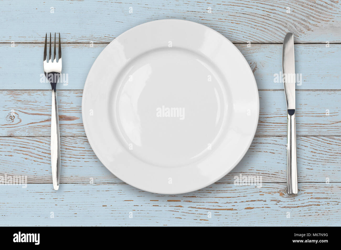 Blu chiaro Tavolo in legno con piastra bianca impostazione vista superiore Foto Stock