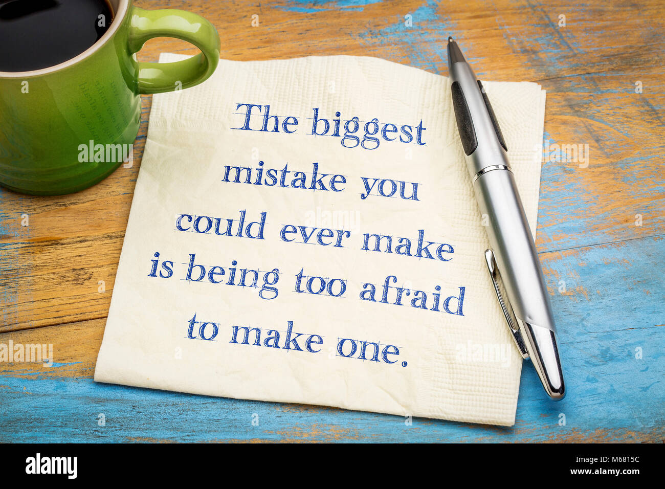 Il più grande errore che si possa fare è troppa paura di fare uno - scrittura su un tovagliolo con una tazza di caffè. Foto Stock