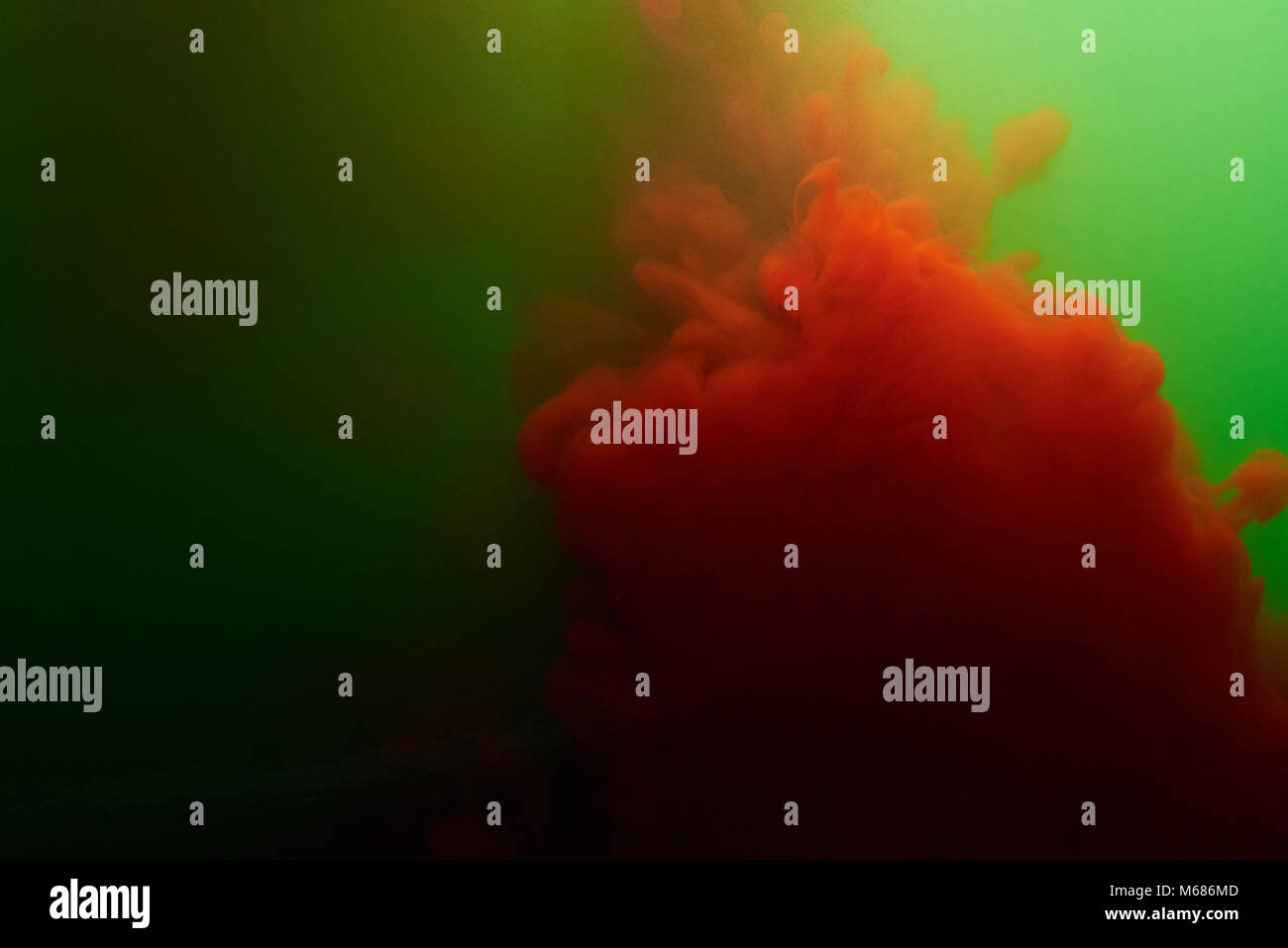 Schizzi di inchiostro rosso in verde acqua. Il liquido colorato sfondo astratto Foto Stock