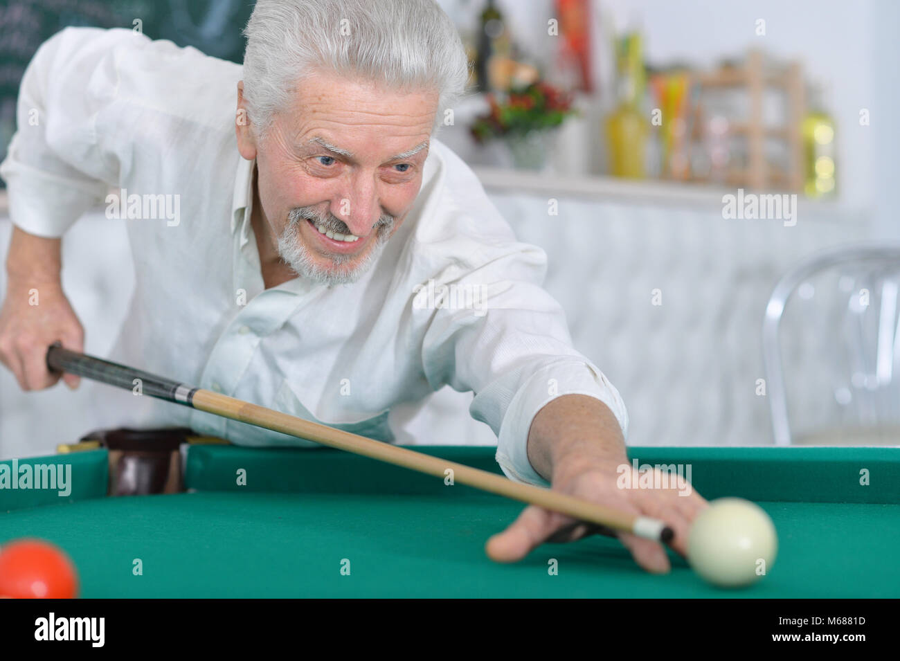 Senior uomo giocando a biliardo Foto Stock