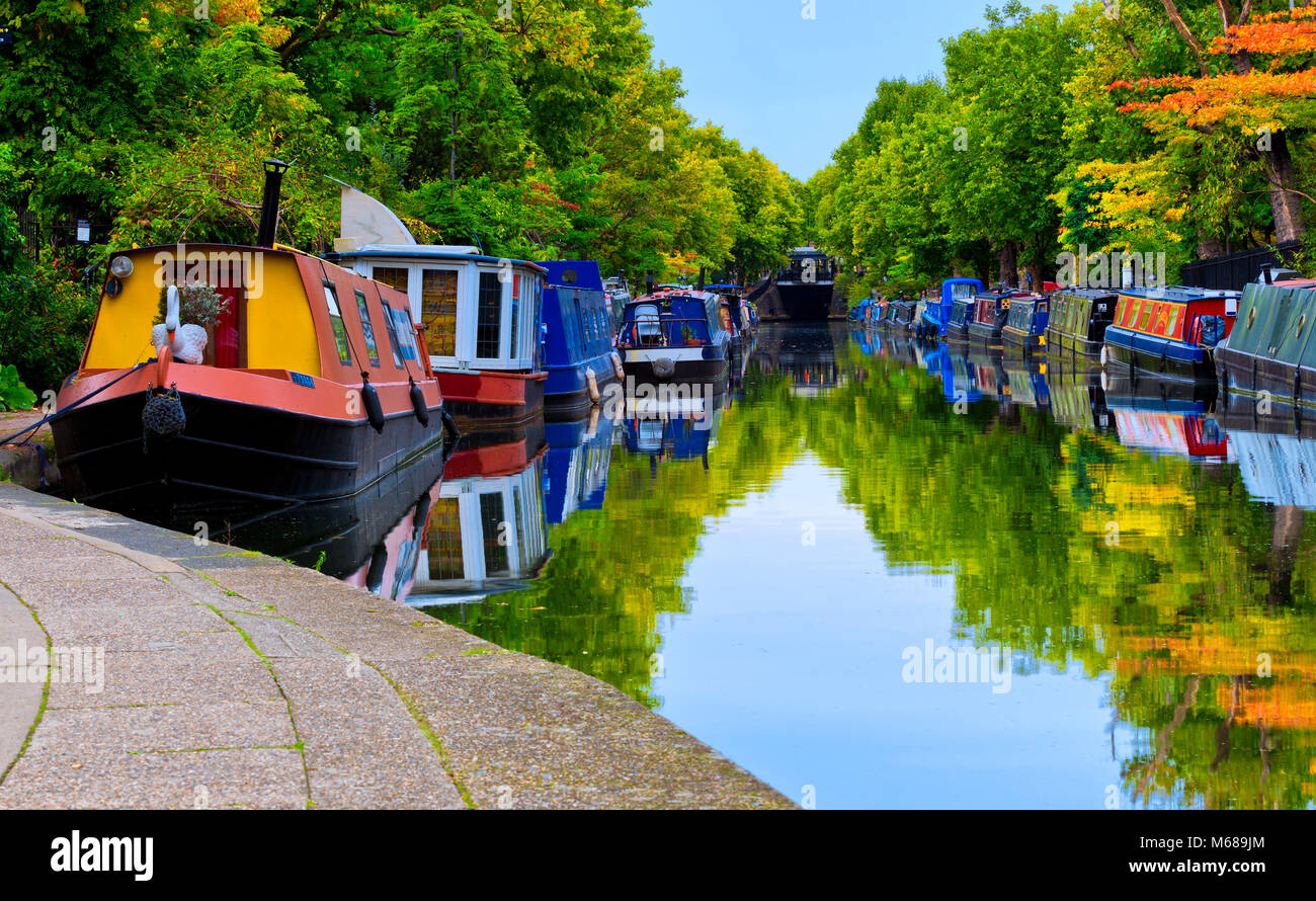 Barche e chiatte in little venice lodon uk con colurful alberi e bel cielo blu e riflessi in acqua Foto Stock