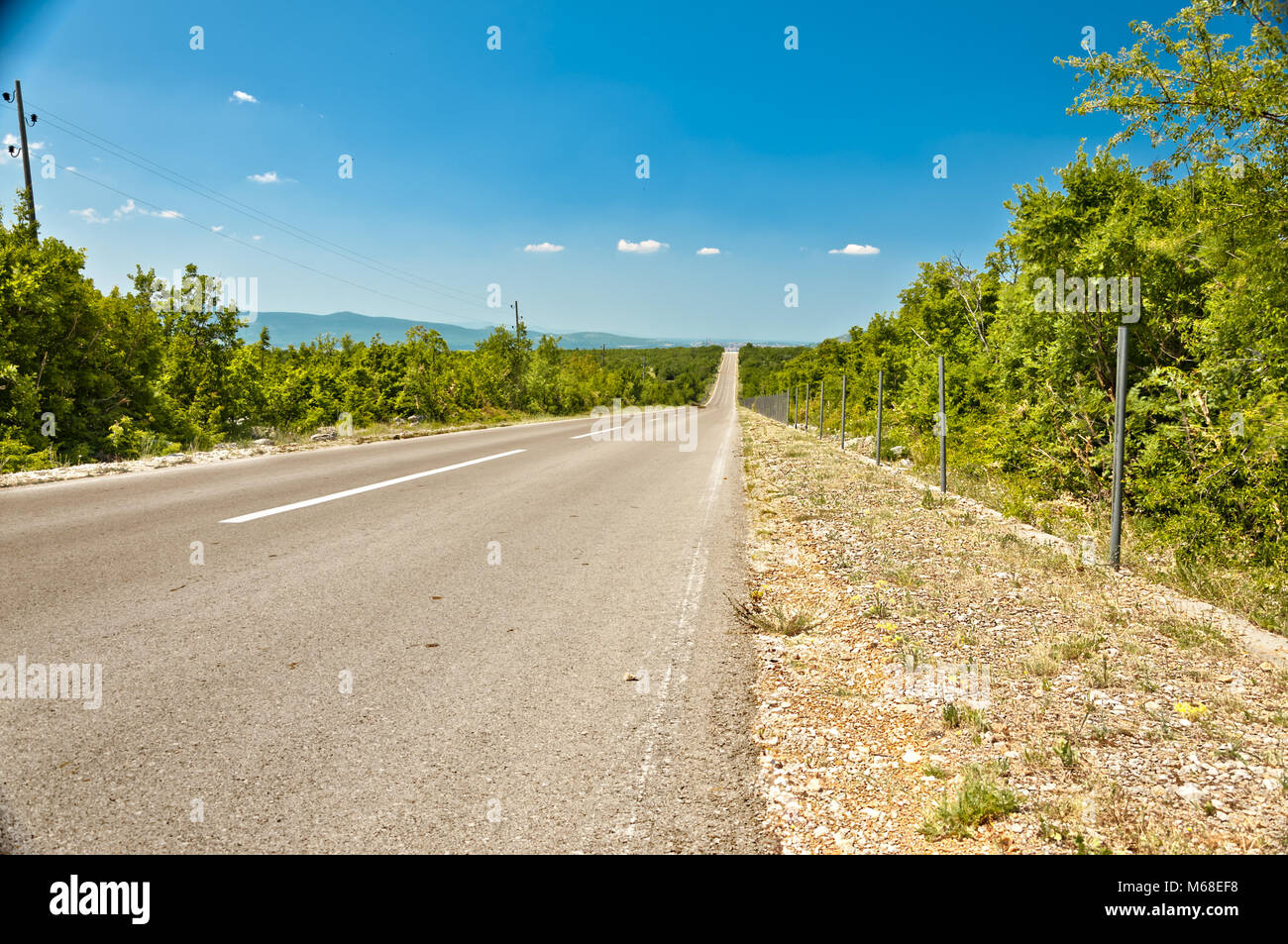 Strada diritta attraverso entroterra dalmata in prossimità della città di drniš Foto Stock