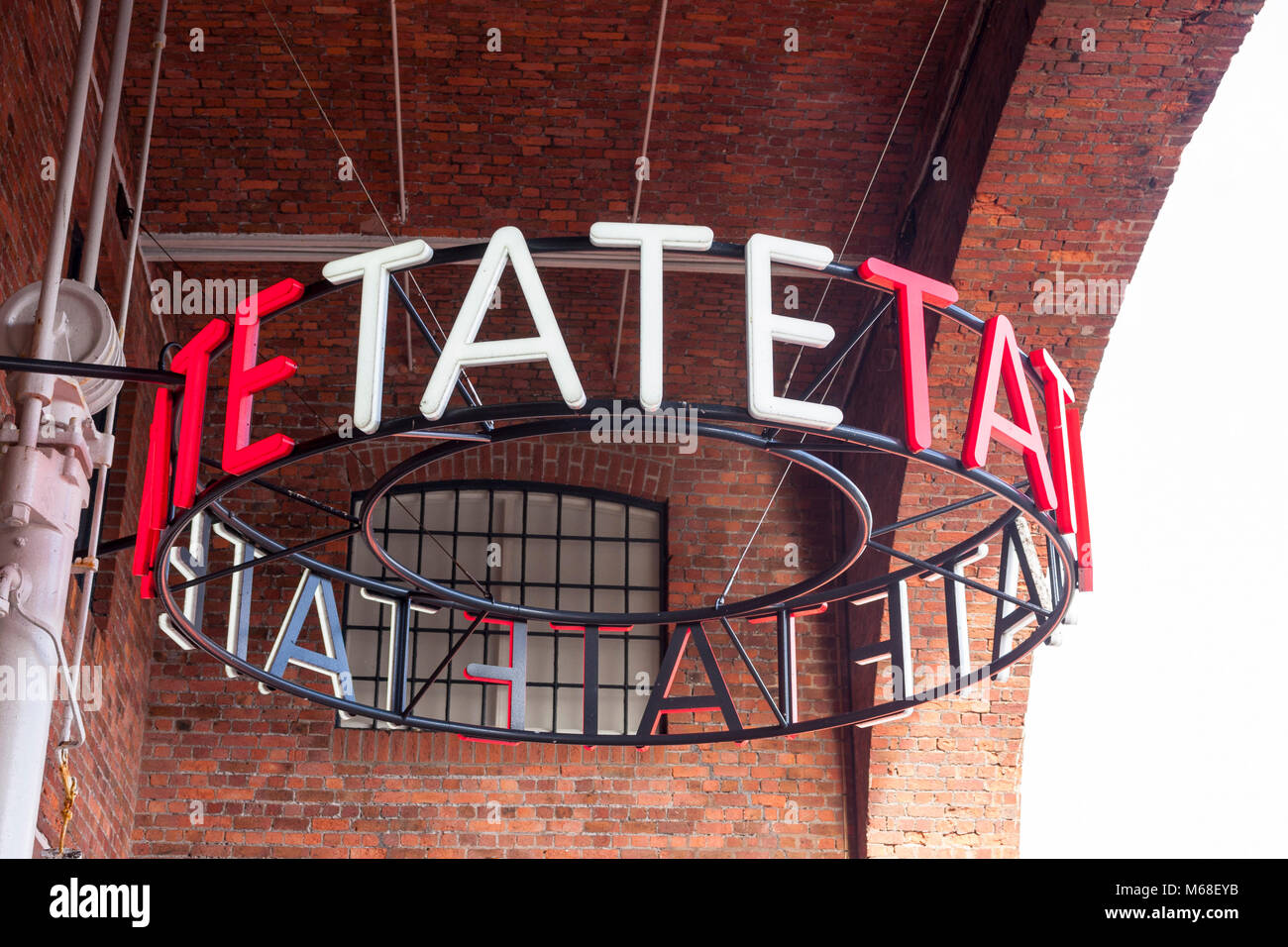 Illuminata Tate firmare all'entrata di Tate Liverpool, Albert Dock, Merseyside Foto Stock