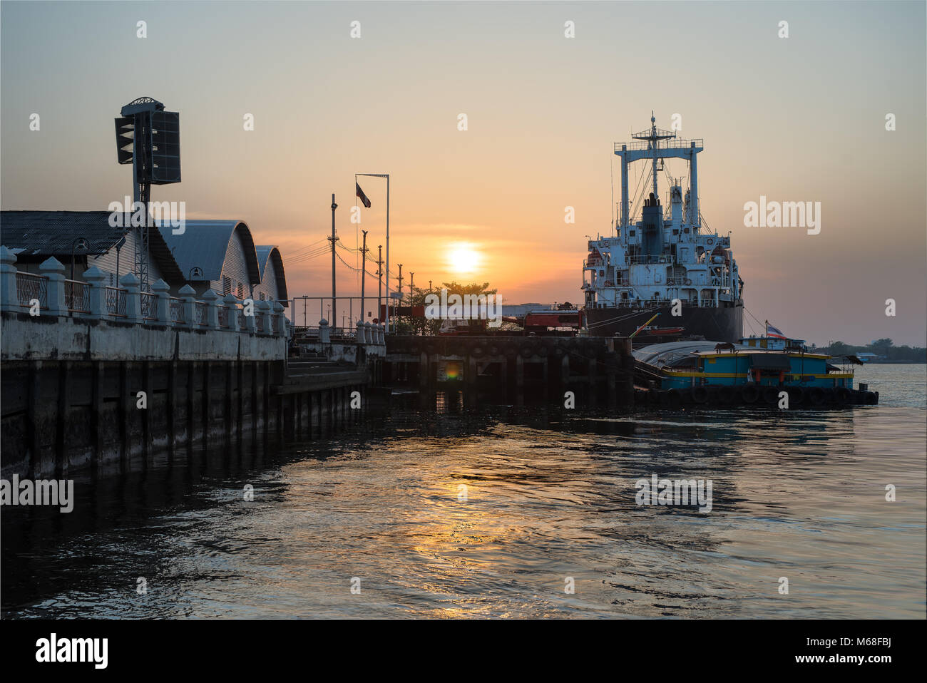 Ocean Liner terra al porto sul fiume che il centro della città sotto il tramonto. Foto Stock