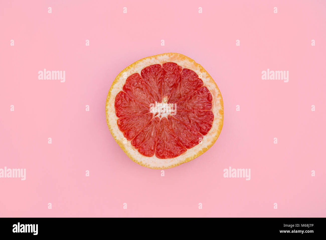 Pompelmo rosa metà overhead sul luminoso sfondo rosa Foto Stock