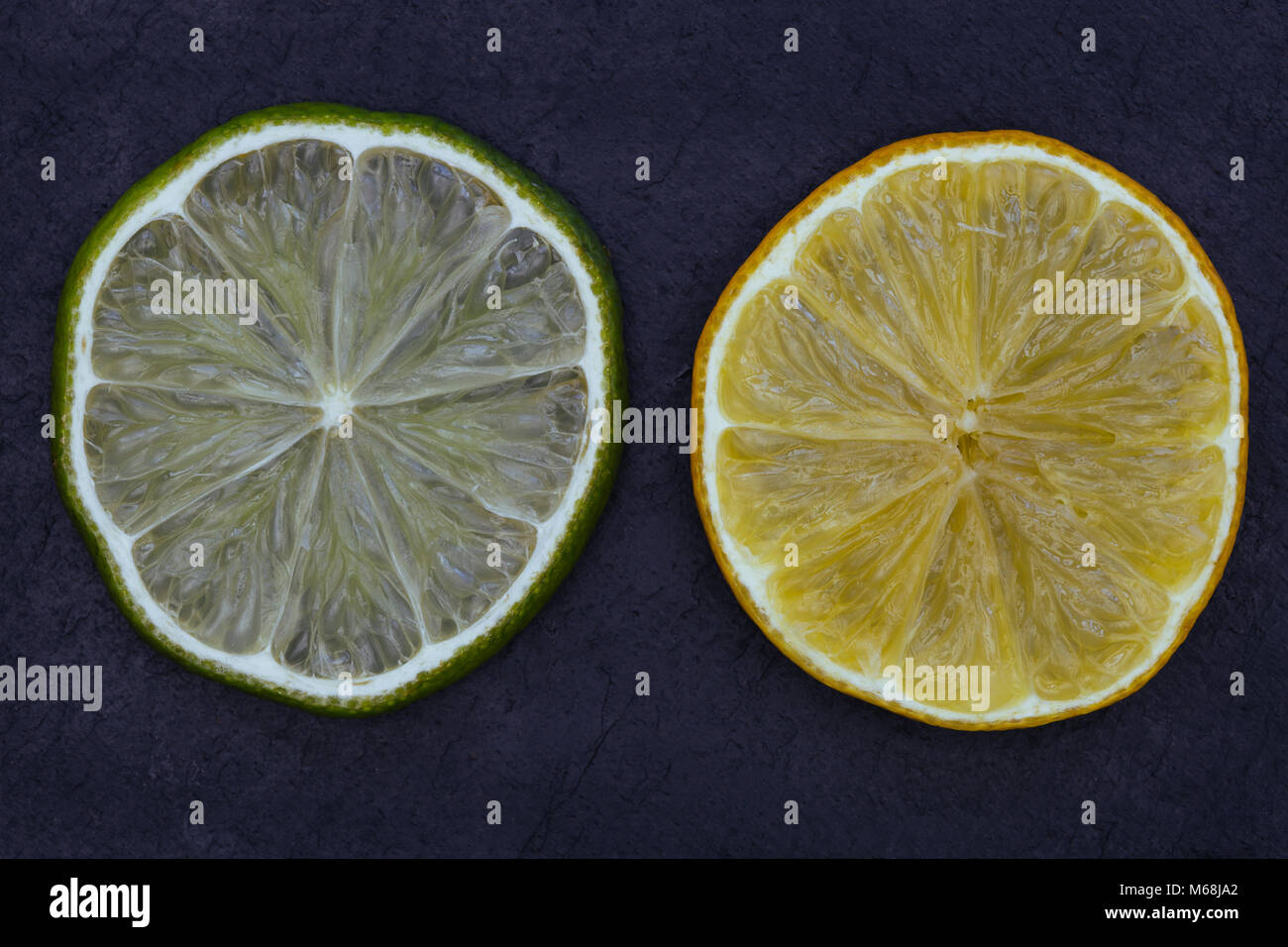 Limone fettine di lime del cibo su sfondo scuro Foto Stock