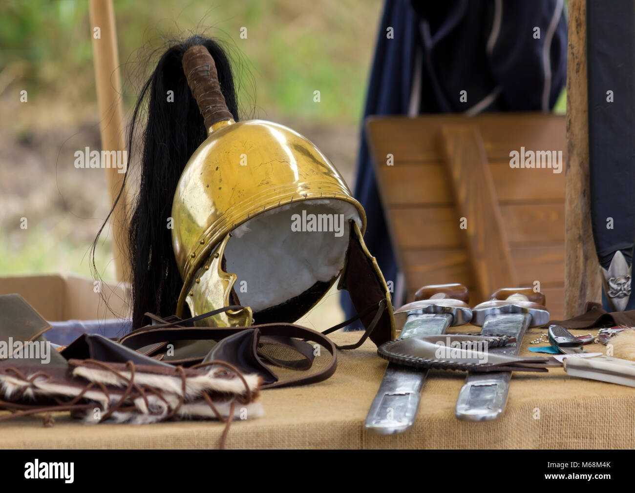 Antico romano casco su una tabella insieme con altre apparecchiature di guerra Foto Stock