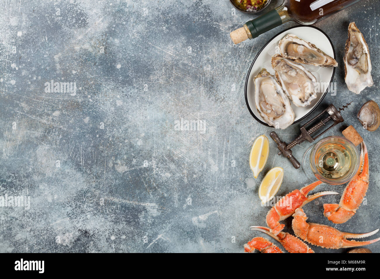 Piatti a base di frutti di mare e vino bianco. Ostriche, aragosta, vongole. Sul tavolo di pietra con spazio per il testo Foto Stock